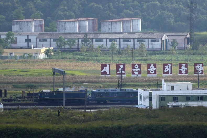 Un tren verde con destellos en amarillo, similar al que utilizó el gobernante norcoreano Kim Jong Un en sus viajes previos, pasa frente a un letrero con la leyenda Hacia una nueva victoria, en la frontera de Corea del Norte con Rusia y China, desde la plataforma panorámica Tres Reinos de Yiyanwang, el lunes 11 de septiembre de 2023, en Fangchuan, en la provincia de Jilin, en el noreste de China. (AP Foto/Ng Han Guan)