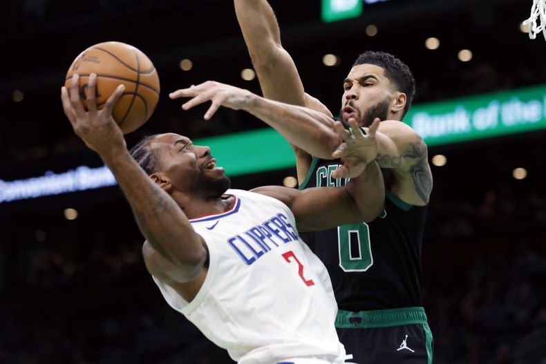 Kawhi Leonard (2) de los Clippers de Los Ángeles lanza ante Jayson Tatum (0) de los Celtics de Boston, durante la primera mitad del juego de baloncesto de la NBA, el sábado 27 de enero de 2024, en Boston. (AP Foto/Michael Dwyer)