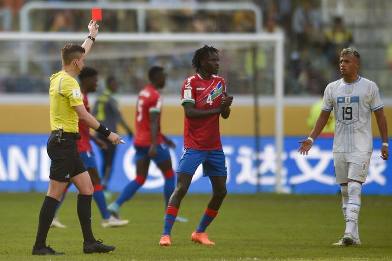 El árbitro francés François Letexier le muestra la tarjeta roja a Luciano Rodríguez de Uruguay, a la derecha, durante el partido contra Gambia por los octavos de final del Mundial Sub20 en el estadio Madre de Ciudades de Santiago del Estero, Argentina, jueves 1 junio, 2023. (AP Foto/Gustavo Garello)