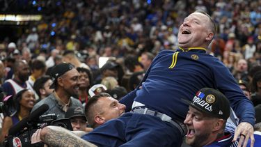 Michael Malone, entrenador de los Nuggets de Denver, es levantado por un grupo de fanáticos tras coronarse en las Finales de la NBA ante el Heat de Miami, el lunes 12 de junio de 2023