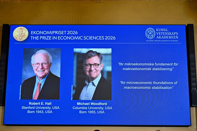 Retratos de Robert E. Hall y Michael Woodford se ven en la pantalla mientras se anuncia que han recibido el Premio del Banco de Suecia de Ciencias Económicas en Memoria de Alfred Nobel, en la Academia Sueca de Ciencias en Estocolmo, Suecia, el lunes 12 de octubre de 2026. (Anders Wiklund/TT News Agency via AP)