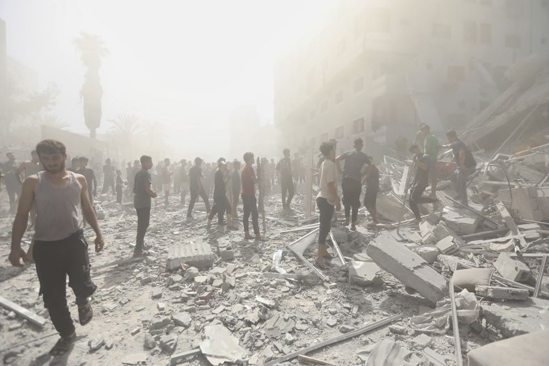 Palestinos inspeccionan los restos de un edificio tras un ataque israelí en Ciudad de Gaza, el domingo 14 de septiembre de 2025. (AP Foto/Yousef Al Zanoun)