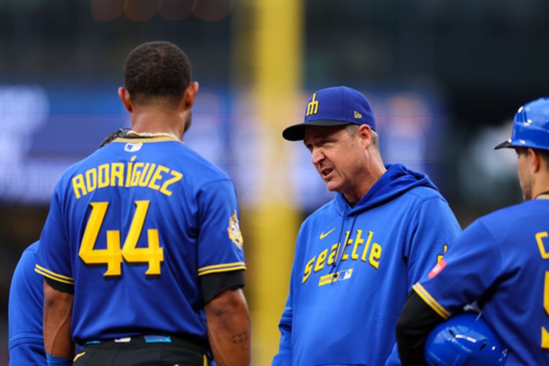 El mánager de los Marineros de Seattle, Dan Wilson, intercambia palabras con Julio Rodríguez tras ser golpeado por la pelota en la primera entrada de un partido de béisbol contra los Angelinos de Los Ángeles, el jueves 2 de julio de 2026, en Seattle. (Foto AP/Kevin Ng)
