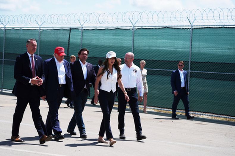 ARCHIVO – El presidente de Estados Unidos, Donald Trump, el gobernador republicano de Florida, Ron DeSantis, y la secretaria de Seguridad Nacional Kristi Noem, junto con otras personas, recorren Alcatraz de los caimanes, un nuevo centro de detención de inmigrantes en la Instalación de Entrenamiento y Transición Dade-Collier, el 1 de julio de 2025, en Ochopee, Florida. (AP Foto/Evan Vucci, Archivo)