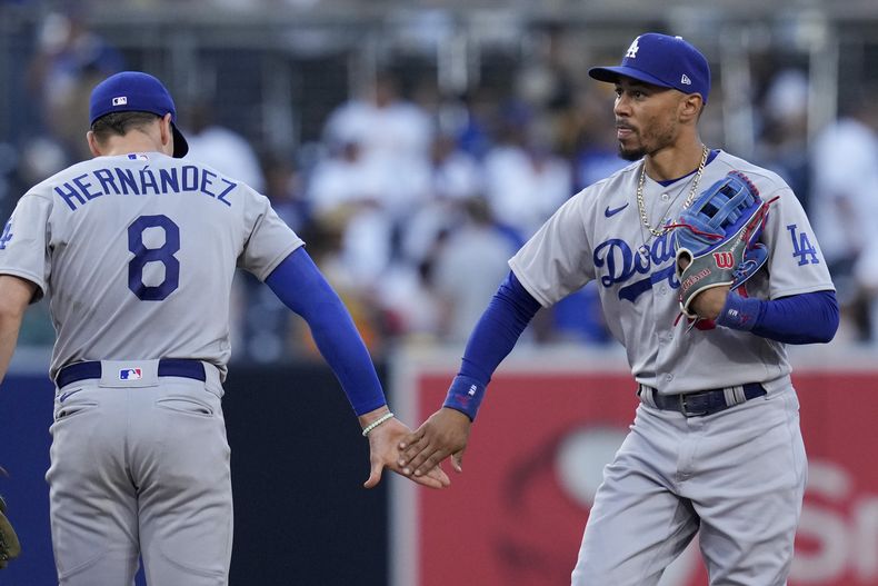 Mookie Betts (derecha) de Los Dodgers de Los Ángeles celebra junto a Kiké Hernández luego de derrotar a los Padres de San Diego por 8-2, en San Diego. Domingo 6 de agosto de 2023. (AP Foto/Gregory Bull)