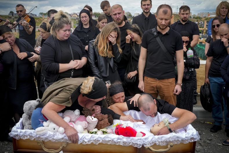 Familiares y amigos en el funeral de una niña que murió en un ataque ruso contra Vinnytsia, Ucrania, el sábado 17 de julio de 2022. (AP Foto/Efrem Lukatsky)