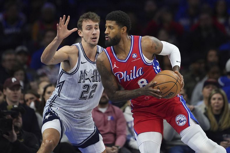 Paul George, derecha, de los 76ers de Filadelfia, busca superar a Franz Wagner, del Magic de Orlando, durante la primera mitad del juego de baloncesto de la NBA, el viernes 6 de diciembre de 2024, en Filadelfia. (AP Foto/Matt Slocum)