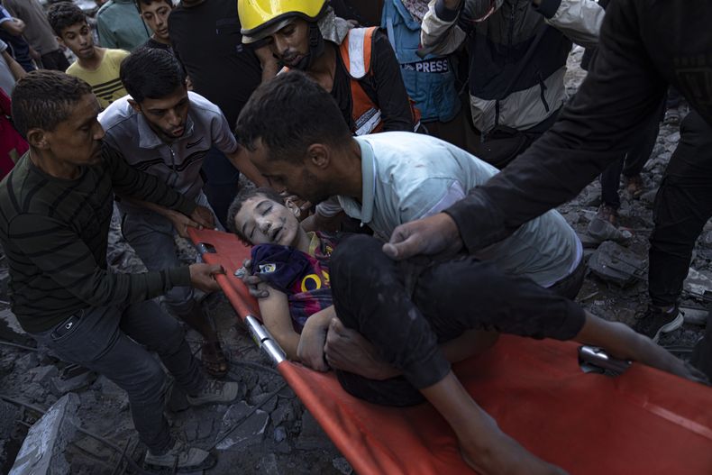 Palestinos evacuan a los heridos tras un bombardeo que destruyó un edificio en Khan Younis, en la Franja de Gaza, el 19 de octubre de 2023. (AP Foto/Fatima Shbair)