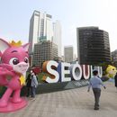 ARCHIVO - Varias personas pasan junto a personajes de Pinkfong, una empresa surcoreana de contenido para niños, durante una campaña de prevención del COVID-19 en la Plaza del Ayuntamiento en Seúl, el 12 de octubre de 2020. En la mascarilla del personaje pone Muchas gracias. (AP Foto/Ahn Young-joon, archivo)
