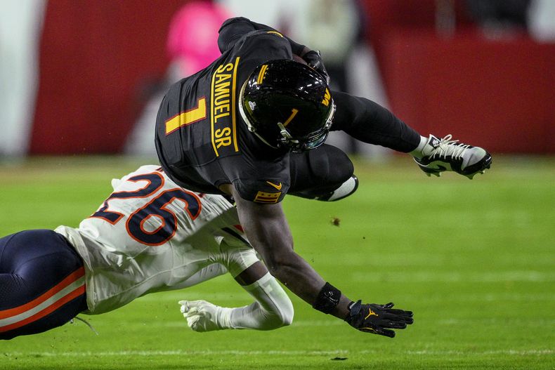 El receptor abierto Deebo Samuel Sr., de los Commanders de Washington, es golpeado por el cornerback Nahshon Wright (26), de los Bears de Chicago, durante la primera mitad de un juego de fútbol americano de la NFL el lunes 13 de octubre de 2025, en Landover, Maryland. (AP Photo/Nick Wass)