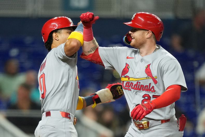 Nathan Church, de los Cardenales de San Luis, a la derecha, celebra con Masyn Winn tras conectar un jonrón de dos carreras para anotar ambos durante la cuarta entrada de un partido de béisbol contra los Marlins de Miami, el martes 21 de abril de 2026, en Miami. (AP Foto/Rebecca Blackwell)
