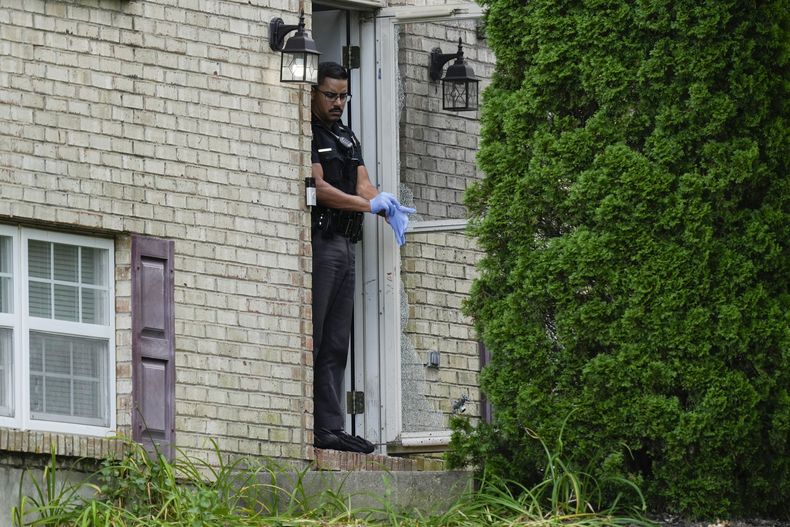 Un miembro del Departamento de Policía de Florence, Kentucky, frente a la puerta de una casa que fue escenario de un tiroteo, el sábado 6 de julio de 2024, en Florence, Kentucky. (AP Foto/Carolyn Kaster)