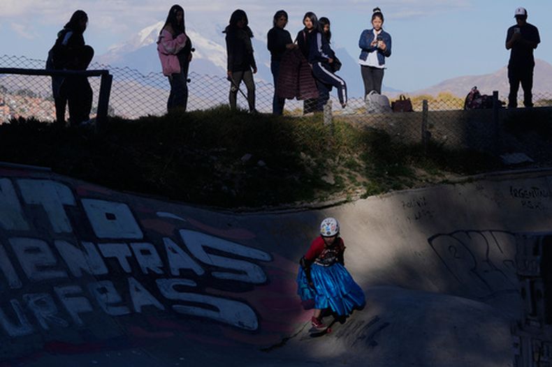 Miriam Fernández, vestida con una falda tradicional cholita, conocida como pollera, monta en patineta durante un concurso de talentos juveniles en La Paz, Bolivia, el jueves 16 de julio de 2026. (Foto AP/Juan Karita)