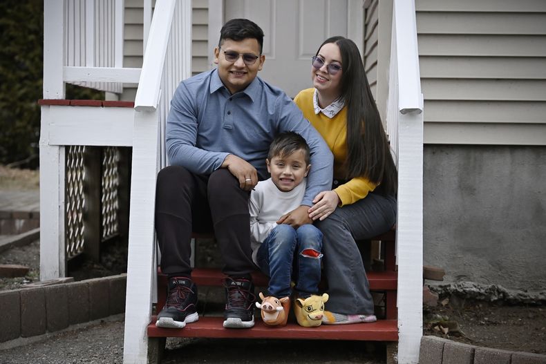 En esta imagen, tomada el 3 de enero de 2025, Rogers López, posa para una foto junto a su esposa, Karina Cañizarez, y su hijo Jesús David en el exterior de su apartamento en New Milford, Connecticut. (AP Foto/Jessica Hill)