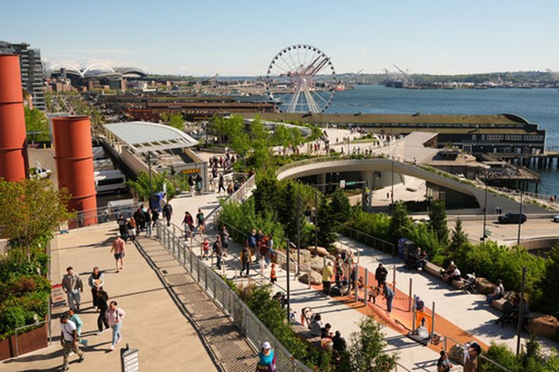 Peatones transitan el malecón que conecta el mercado de Pike Place con la costa de Seattle en Elliott Bay, el sábado 25 de abril de 2026, en Seattle. (AP Foto/Lindsey Wasson)