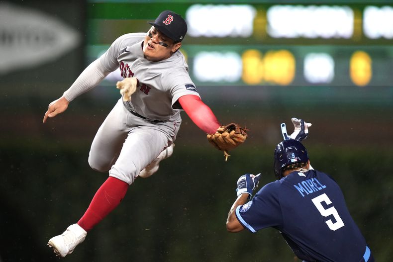 El dominicano Christopher Morel, de los Cachorros de Chicago, se roba la intermedia frente a Yu Chang, de los Medias Rojas de Boston, el viernes 14 de julio de 2023 (AP Foto/Charles Rex Arbogast)