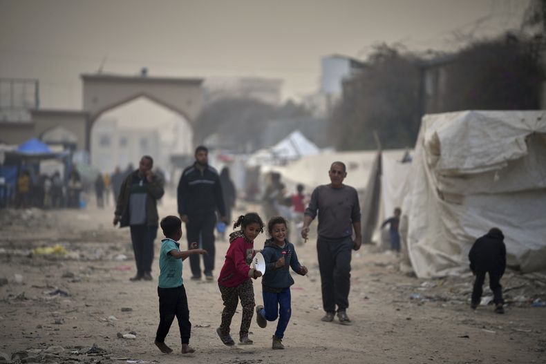 Palestinos desplazados caminan junto a carpas en la Universidad Islámica del complejo de Gaza durante la guerra en Gaza, el domingo 6 de abril de 2025. (AP Foto/Jehad Alshrafi)
