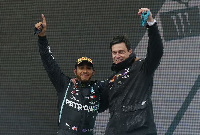 ARCHIVO - Foto del 15 de noviembre del 2020, el piloto de Mercedes Lewis Hamilton celebra con el jefe de la escudería Toto Wolff tras ganar la carrera y su séptimo título de F1. (AP Foto/Kenan Asyali, Pool, Archivo)