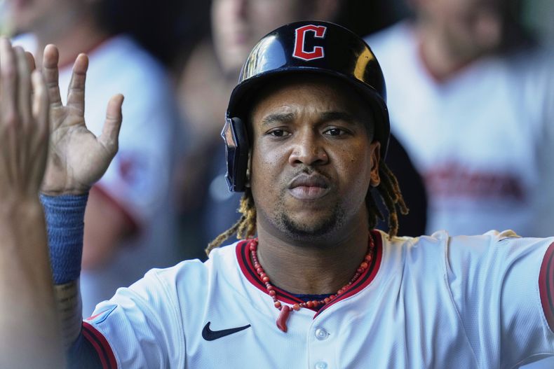 El dominicano José Ramírez, de los Guardianes de Cleveland, es felicitado en el dugout después de anotar en la primera entrada de un juego de béisbol contra los Marlins de Miami en Cleveland, el jueves 14 de agosto de 2025. (AP Photo/Sue Ogrocki)