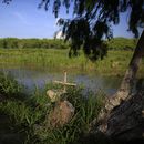 Una cruz marca un monumento funerario en las márgenes del río Bravo _Rio Grande en inglés_ en la frontera de México con Texas, donde muchos migrantes han perdido la vida al intentar cruzar, el jueves 27 de junio de 2019, en Matamoros, estado de Tamaulipas. (AP Foto/Rebecca Blackwell)