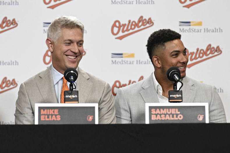 Mike Elias, vicepresidente ejecutivo de los Orioles de Baltimore, y el cátcher novato dominicano Samuel Basallo, sonríen en una conferencia de prensa el sábado 23 de agosto de 2025 (AP Foto/Terrance Williams)