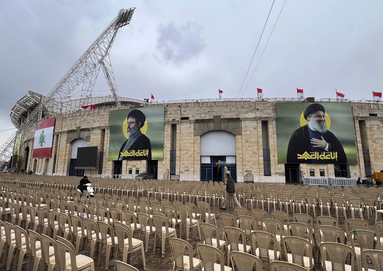 Gente pasa entre sillas colocadas ante el estadio City Sportive de Beirut el día antes del funeral de los líderes de Hezbollah Sayyed Hassan Nasrallah y Sayyed Hashem Safieddine, en Beirut, Líbano, el sábado 22 de febrero de 2025. (AP Foto/Hussein Malla)