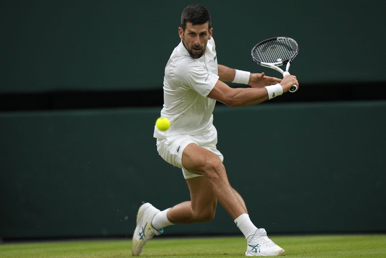 El serbio Novak Djokovic regresa una bola en el duelo de semifinales ante el italiano Jannik Sinner en Wimbledon el viernes 14 de julio del 2023. (AP Foto/Alastair Grant)