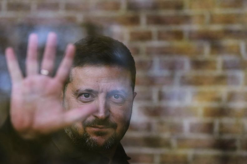 El presidente de Ucrania, Volodymyr Zelenskyy, saluda al otro lado de una ventana tras recibir la Medalla de la Libertad en la ceremonia del International Four Freedoms Award en Middelburg, Países Bajos, el jueves 16 de abril de 2026. (AP Foto/Peter Dejong)