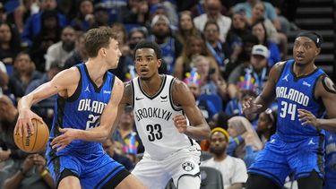 Frans Wagners, alero del Magic de Orlando, intenta enviar un pase frente a Nic Claxton, de los Nets de Brooklyn, en el partido del martes 27 de febrero de 2024 (AP Foto/John Raoux)
