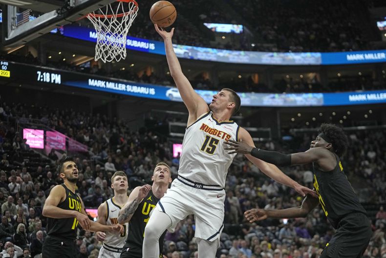 El pívot de los Nuggets de Denver Nikola Jokic avanza hacia la canasta con el balón para anotar frente al pívot del Jazz de Utah el martes 9 de abril del 2024. (AP Foto/Rick Bowmer)