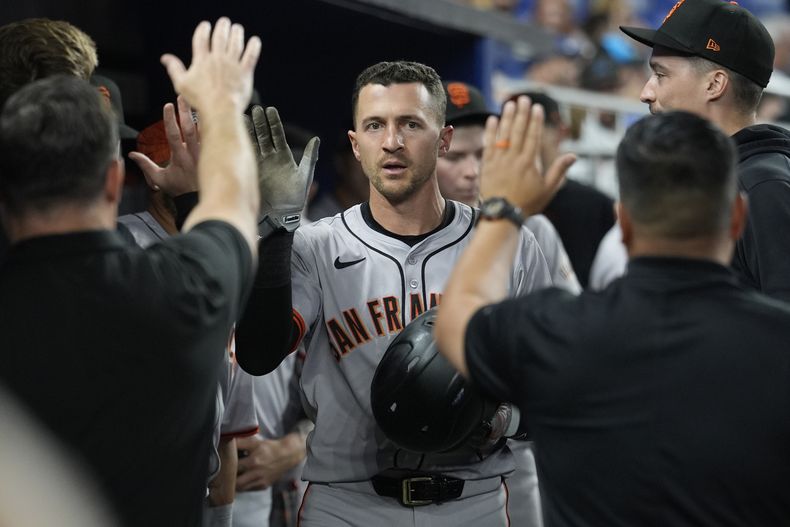 Nick Ahmed, de los Gigantes de San Francisco, anota la carrera de la ventaja con un hit del venezolano Wilmer Flores durante la séptima entrada de un juego de béisbol contra los Marlins de Miami, el lunes 15 de abril de 2024, en Miami. (AP Foto/Marta Lavandier)