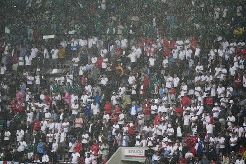 El público soporta la lluvia antes del partido de octavos de final de la Copa del Mundo entre México e Inglaterra, el domingo 5 de julio de 2026 (AP Foto/Fernando Llano)