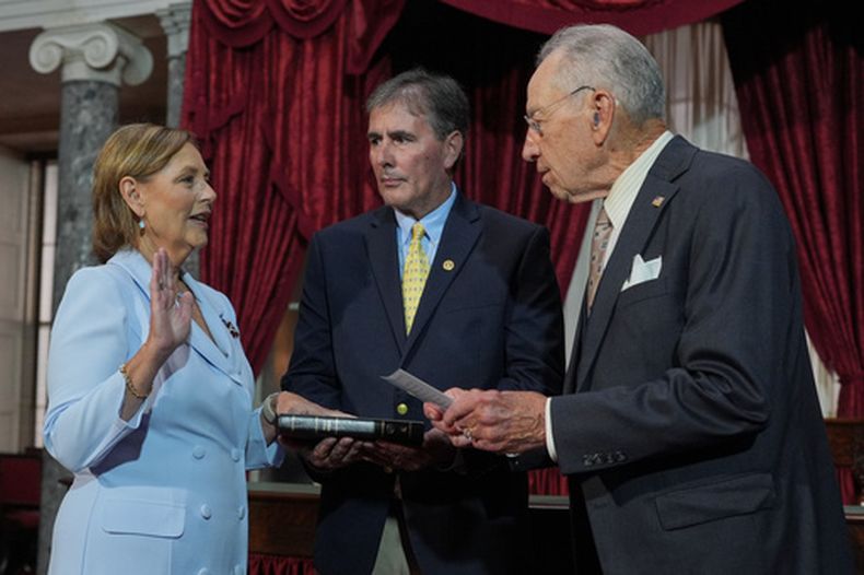 Darline Graham, hermana del fallecido senador Lindsey Graham, republicano de Carolina del Sur, juramenta para completar el periodo legislativo de su hermano, en la antigua cámara del Senado en el Capitolio de Washington, el martes 14 de julio de 2026, mientras su marido Larry Nordone sostiene la Biblia. (Foto AP/J. Scott Applewhite)
