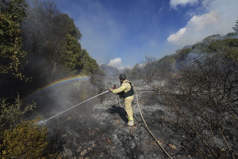 Un bombero israelí trabaja para extinguir un incendio después de que un cohete lanzado desde Líbano cayera en campo abierto en el norte de Israel, el miércoles 18 de septiembre de 2024. (AP Foto/Baz Ratner)