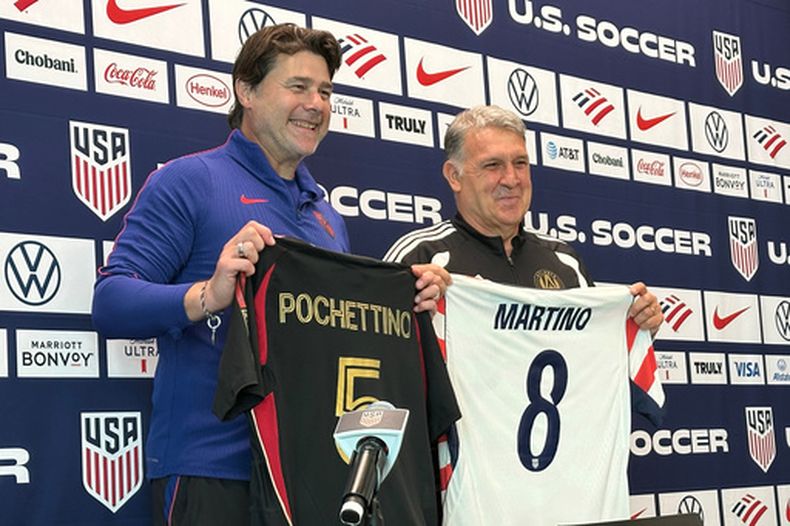El argentino Mauricio Pochettino, entrenador de Estados Unidos, y la entrenadora del Atlanta United, Tara Martino, posan con camisetas durante una conferencia de prensa antes del entrenamiento de la selección nacional masculina de fútbol, el viernes 27 de marzo de 2026, en Marietta, Georgia. (Foto AP/Ronald Blum)