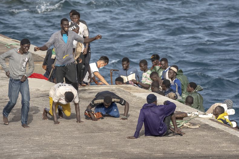 ARCHIVO – Un grupo de migrantes reacciona al llegar al puerto de La Restinga, en El Hierro, islas Canarias, España, el 19 de agosto de 2024. (AP Foto/Maria Ximena, Archivo)