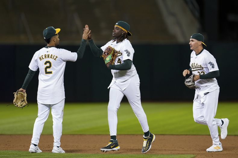 El campocorto puertorriqueño de los Atléticos de Oakland Darell Hernaiz (izquierda) y el jardinero derecho Lawrence Butler (4) celebran luego de la victoria del equipo sobre los Marlins de Miami, en el juego de béisbol, el viernes 3 de mayo de 2024, en Oakland, California. (AP Foto/Godofredo A. Vásquez)