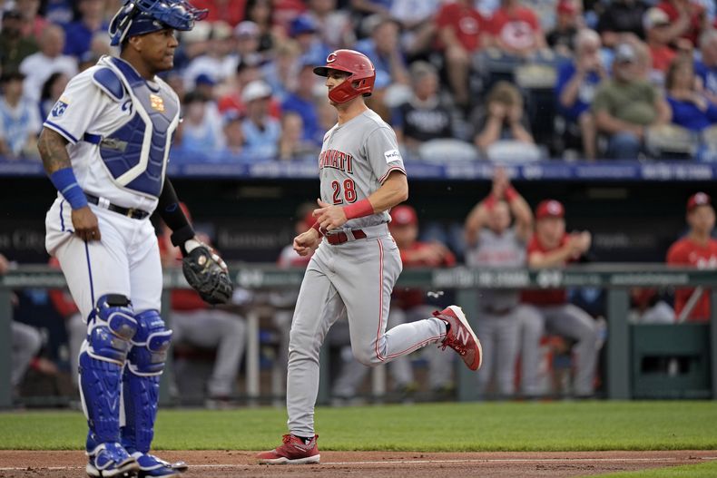 Kevin Newman, de los Rojos de Cincinnati, anota frente al cátcher venezolano Salvador Pérez, de los Reales de Kansas City, el martes 13 de junio de 2023 (AP Foto/Charlie Riedel)