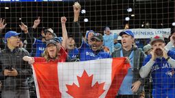 Aficionados de los Azulejos de Toronto celebran la victoria ante los Marineros de Seattle en el tercer juego de la serie de campeonato de la Liga Americana, el miércoles 15 de octubre de 2025. (Frank Gunn/The Canadian Press vía AP)