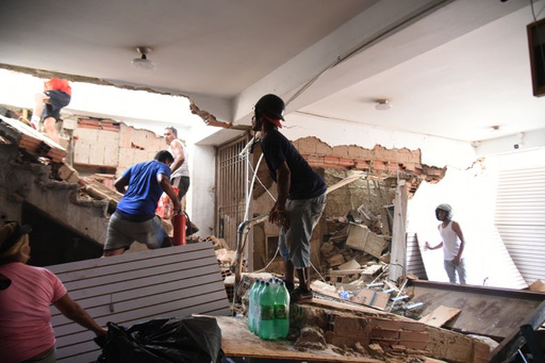 Varias personas retiran mercancías de una tienda dañada un día después de que un terremoto y varias réplicas sacudieran Catia La Mar, Venezuela, el jueves 25 de junio de 2026. (AP Foto/Jonathan Lanza)