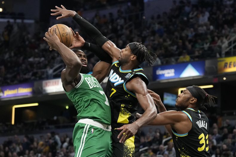 Jaylen Brown, de los Celtics de Boston, recibe una falta de Buddy Hield, de los Pacers de Indiana, en el encuentro del sábado 6 de enero de 2024 (AP Foto/AJ Mast)