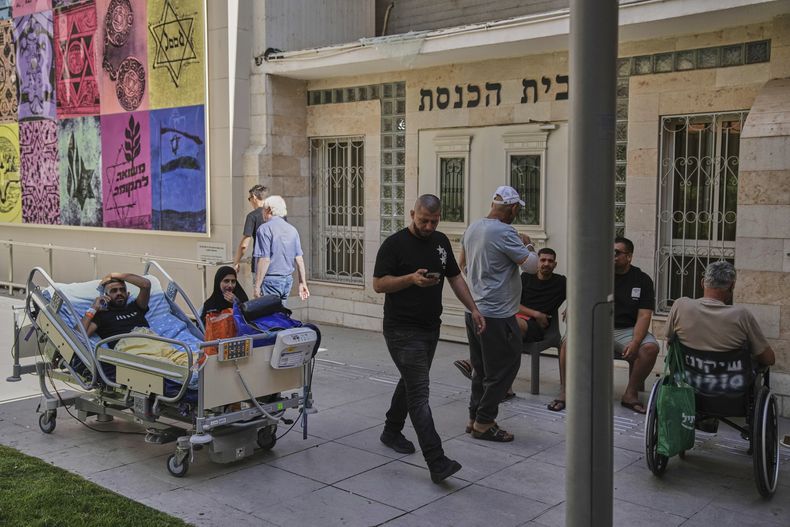 Pacientes descansan al aire libre tras el impacto de un misil lanzado desde irán en el complejo hospitalario de Soroka en Beersheba, Israel, el jueves 19 de junio de 2025. (AP Foto/Leo Correa)
