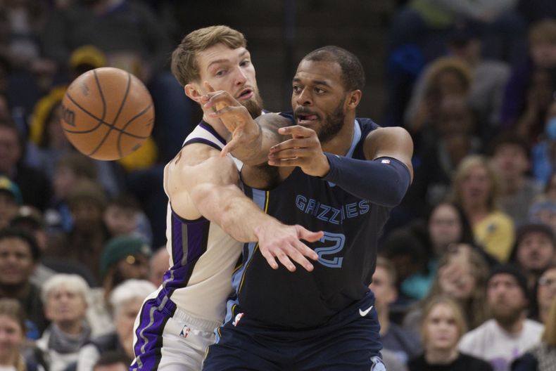 Xavier Tillman (2), de los Grizzlies de Memphis, pasa el balón bajo la presión defensiva de Domantas Sabonis, izquierda, de los Kings de Sacramento, en la segunda mitad del juego de baloncesto de la NBA, el lunes 29 de enero de 2024, en Memphis, Tennessee. (AP Foto/Nikki Boertman)