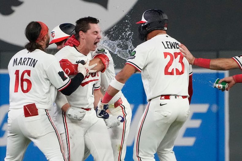 Alan Roden, centro izquierda, de los Mellizos de Minnesota, celebra con sus compañeros de equipo después de batear un sencillo decisivo que impulsó a Royce Lewis en la novena entrada del juego de béisbol de Grandes Ligas contra los Guardianes de Cleveland, el miércoles 8 de julio de 2026, en Minneapolis. (AP Foto/Joseph Scheller)