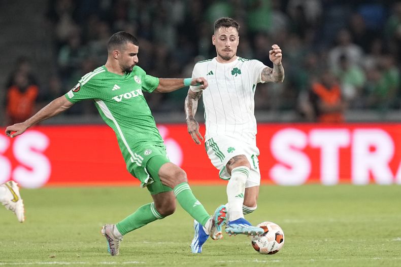Mahmoud Jaber (izquierda) defensa del Maccabi Haifa, y Daniel Mancini del Panathinaikos disputan el baalón durante un partido de la Liga Europa de la UEFA, en Haifa, Israel, el martes 5 de octubre de 2023. (AP Foto/Ohad Zwigenberg)