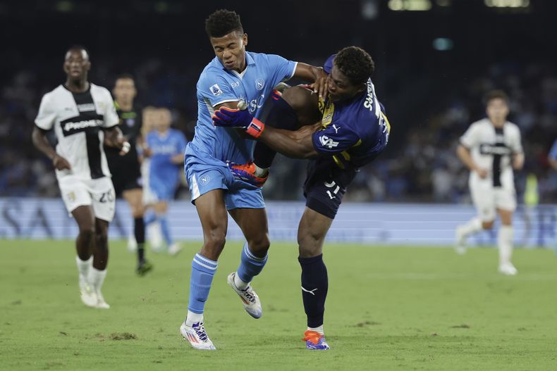 David Neres (derecha) de Napoli y el arquero Zion Suzuki de Parma durante el partido de la Serie A de Italia, el sábado 31 de agosto de 2024, en Nápoles. (Alessandro Garofalo/LaPresse via AP)