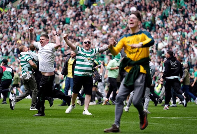 Aficionados del Celtic invaden la cancha al final del partido de fútbol de la Premiership escocesa contra el Heart of Midlothian en Glasgow, Escocia, el sábado 16 de mayo de 2026. (Andrew Milligan/PA vía AP)