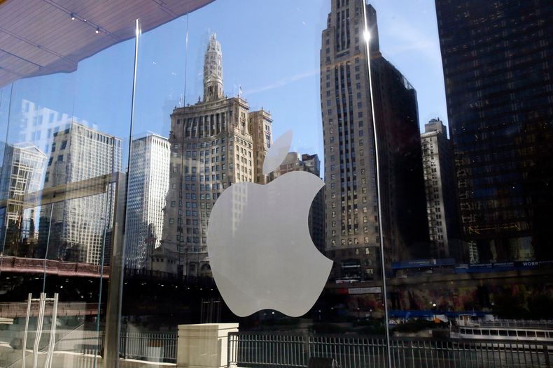 ARCHIVO - Edificios se reflejan detrás del logo de una tienda de Apple, en el centro de Chicago, el 19 de octubre de 2017. (AP Foto/Kiichiro Sato, archivo)
