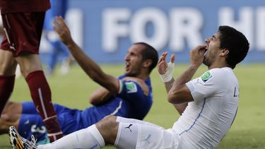 americateve | El uruguayo Luis Su&aacute;rez se lleva una mano a los dientes luego de dar una aparente mordida a Giorgio Chiellini, de Italia, durante el partido del Grupo D mundialista, el martes 24 de junio de 2014, en Natal, Brasil (AP Foto/Ricardo Mazal&aacute;n)
