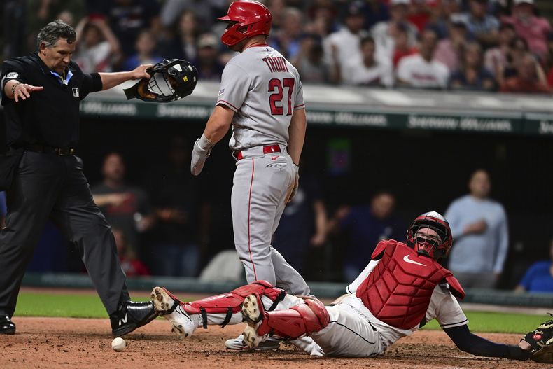 Mike Trout, de los Angelinos de Los Ángeles, llega a salvo al plato, anotando en contra del receptor de los Guardianes de Cleveland, Cam Gallagher, durante la novena entrada del juego de béisbol, el viernes 12 de mayo de 2023, en Cleveland. Los Angelinos ganaron 5-4. (AP Foto/David Dermer)